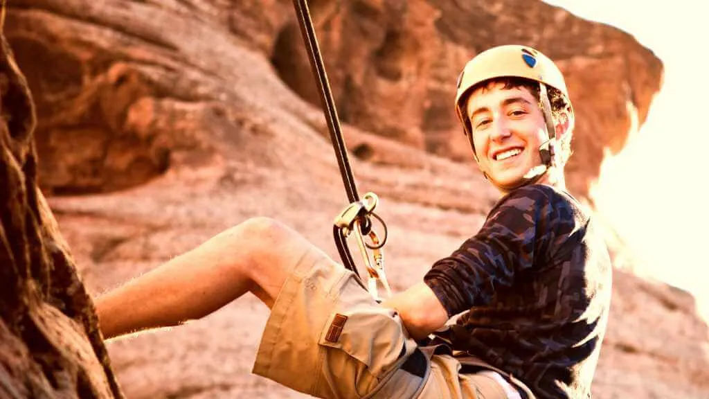 niño en rappel practicando turismo de aventura