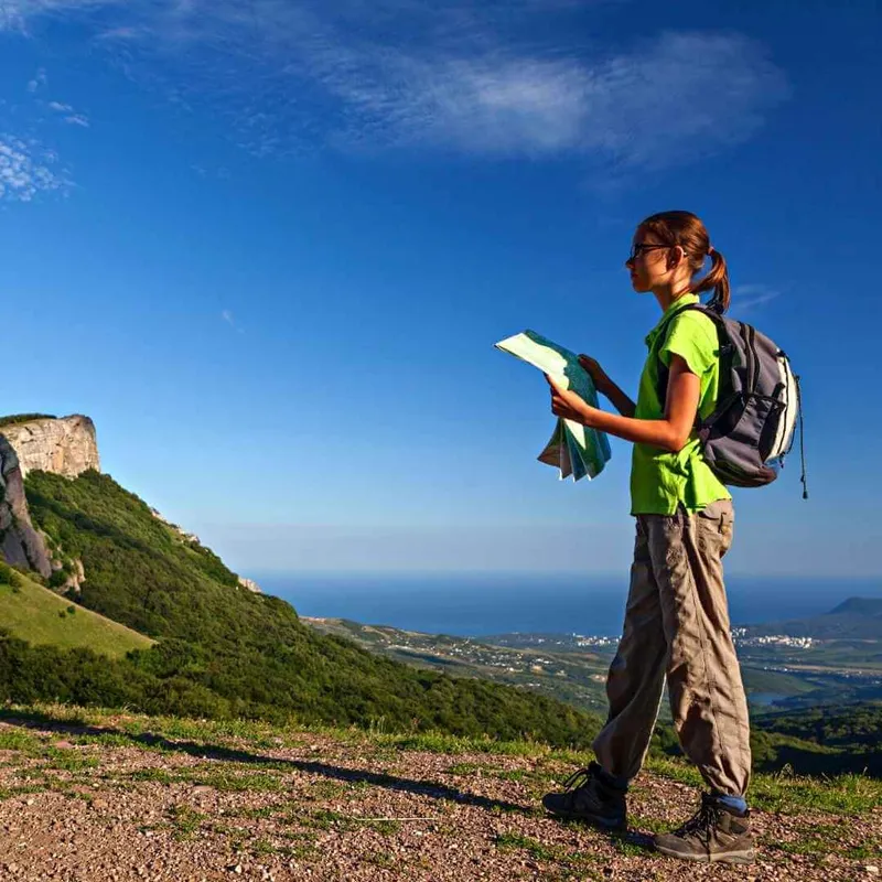 niña en sendero con mapa